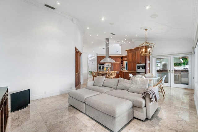 living room with ornamental molding, french doors, and a notable chandelier