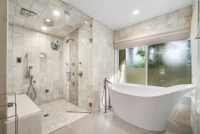 bathroom featuring plus walk in shower, tile patterned flooring, and tile walls