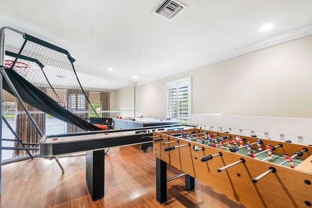 game room with ornamental molding, a textured ceiling, and hardwood / wood-style flooring