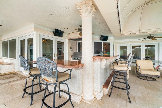 view of patio featuring french doors, an outdoor bar, a grill, and ceiling fan