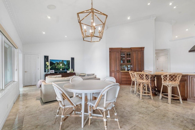 dining room with an inviting chandelier, a high ceiling, and ornamental molding