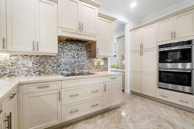 kitchen featuring ornamental molding, tasteful backsplash, cream cabinets, black electric cooktop, and double oven