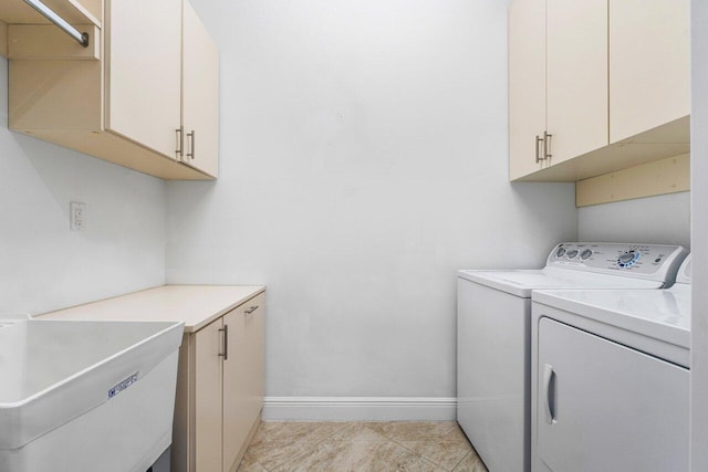 laundry area featuring light tile patterned flooring, independent washer and dryer, and cabinets