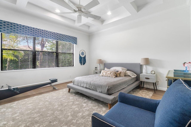 bedroom featuring beam ceiling, coffered ceiling, hardwood / wood-style floors, crown molding, and ceiling fan