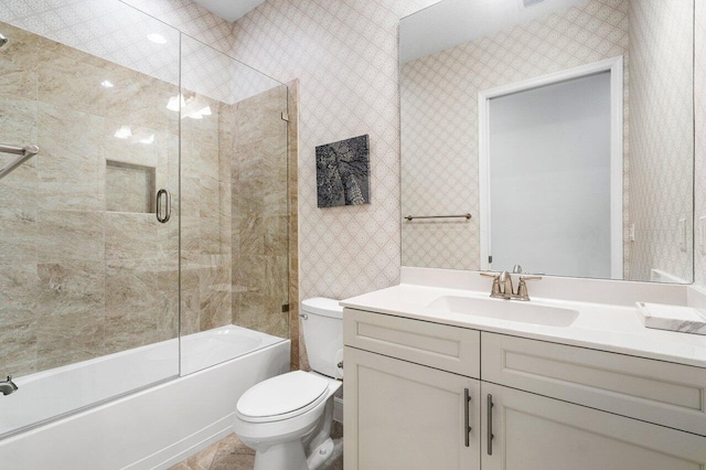 full bathroom with combined bath / shower with glass door, vanity, and toilet