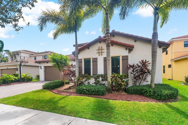 mediterranean / spanish home with a front lawn and a garage