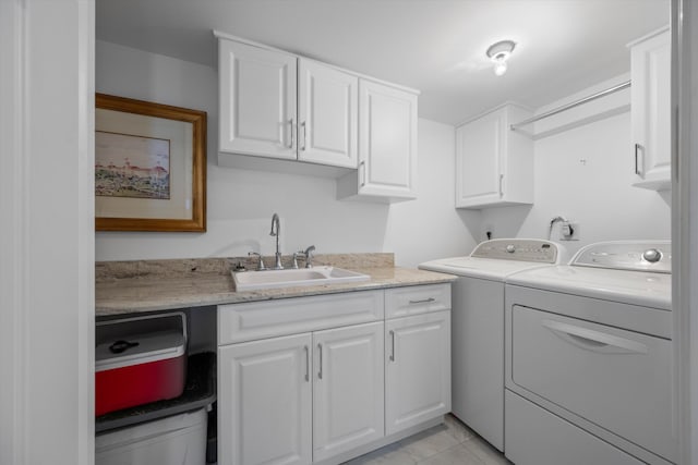 laundry room with washing machine and dryer, sink, and cabinets