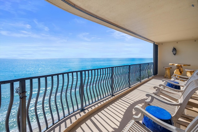 balcony featuring a beach view and a water view