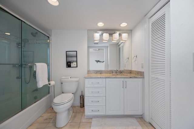 full bathroom featuring enclosed tub / shower combo, vanity, tile patterned flooring, and toilet