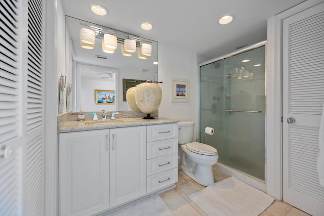 bathroom with tile patterned floors, an enclosed shower, vanity, and toilet