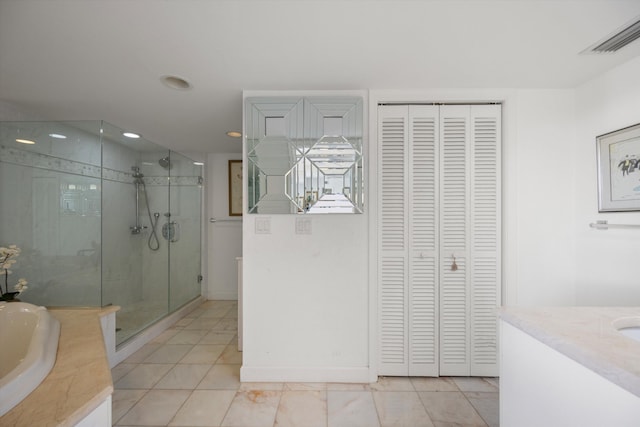 bathroom with independent shower and bath, vanity, and tile patterned floors