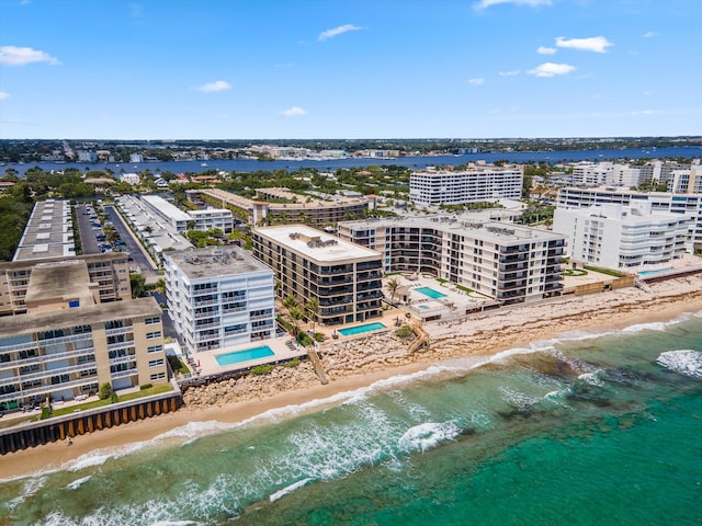 birds eye view of property featuring a water view and a beach view