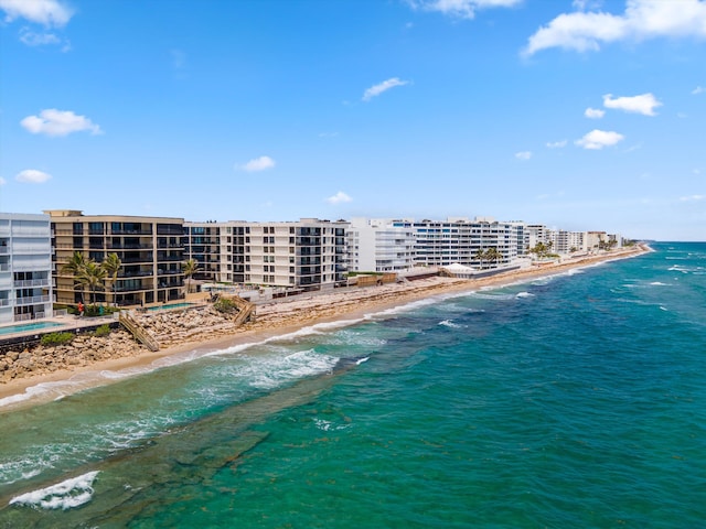 drone / aerial view with a water view and a beach view