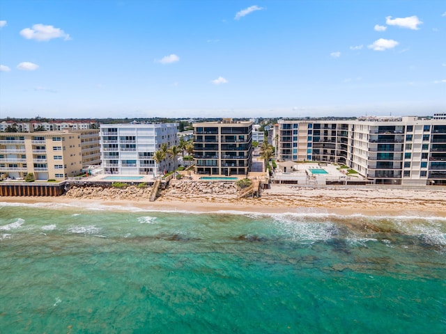 birds eye view of property with a water view and a beach view