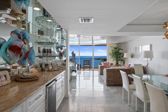 bar with white cabinets, beverage cooler, light stone countertops, and floor to ceiling windows