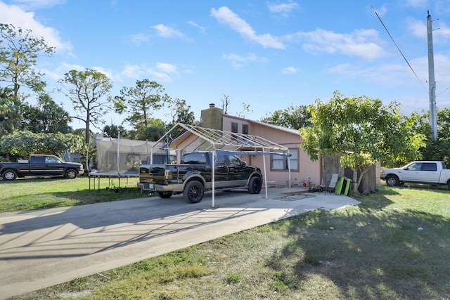 view of front of home featuring a front yard and a trampoline