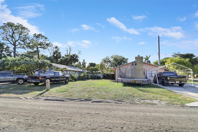 view of front of house with a carport and a trampoline