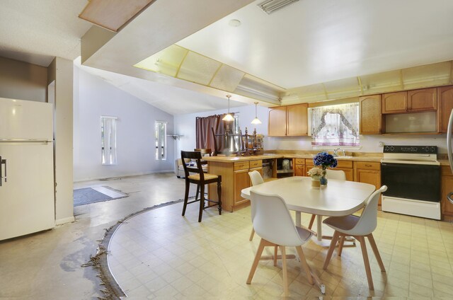 kitchen with white appliances, vaulted ceiling, sink, hanging light fixtures, and a breakfast bar area