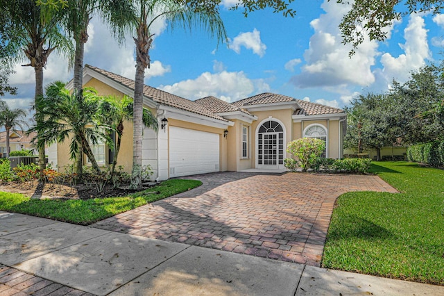 mediterranean / spanish-style home with a front yard and a garage