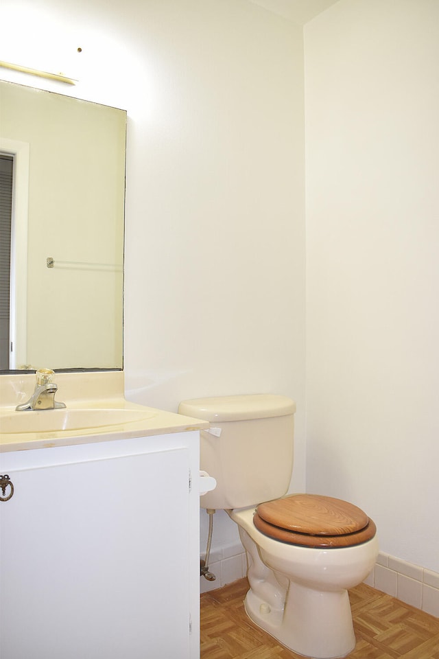 bathroom with vanity, parquet flooring, and toilet