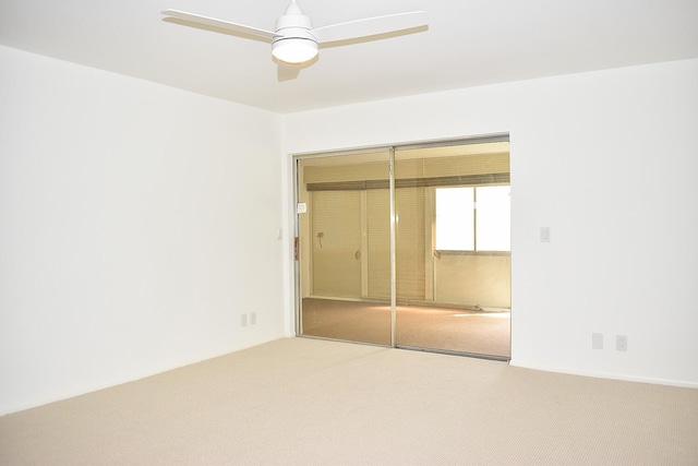 unfurnished bedroom featuring carpet, ceiling fan, and a closet