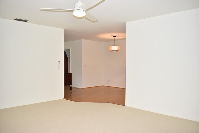 carpeted spare room with ceiling fan