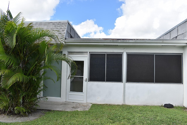 view of side of property with a sunroom and a yard