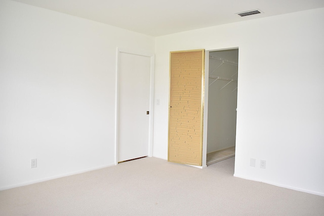 unfurnished bedroom featuring carpet flooring, a spacious closet, and a closet