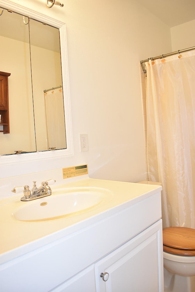 bathroom with a shower with curtain, vanity, and toilet