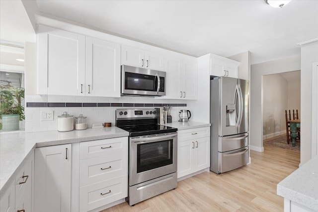 kitchen featuring stainless steel appliances, tasteful backsplash, white cabinets, and light hardwood / wood-style flooring