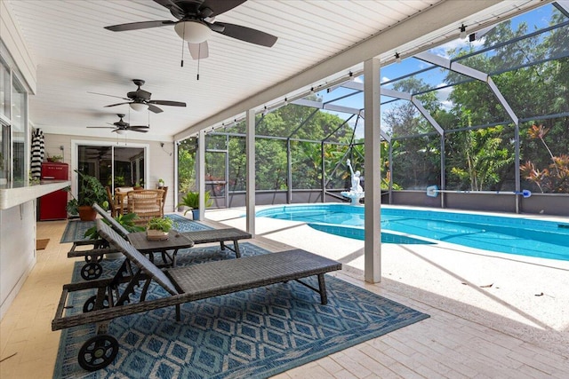 view of swimming pool featuring ceiling fan, a patio area, and glass enclosure