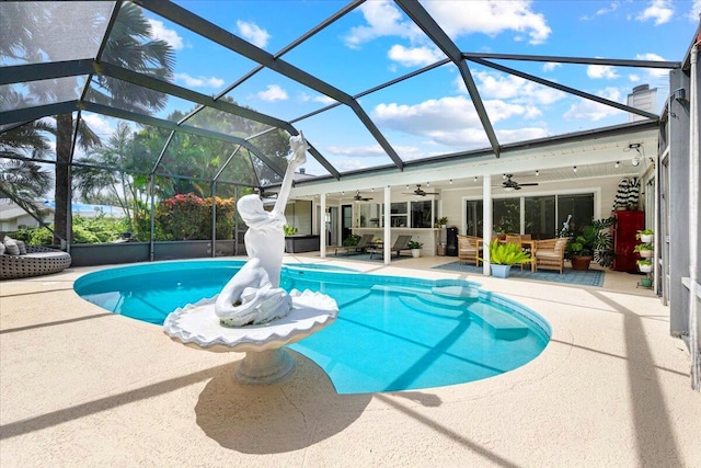 view of pool with ceiling fan, a lanai, and a patio