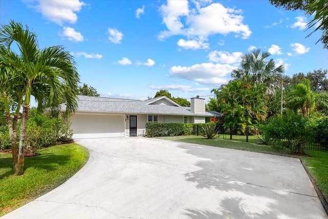 single story home featuring a garage and a front lawn