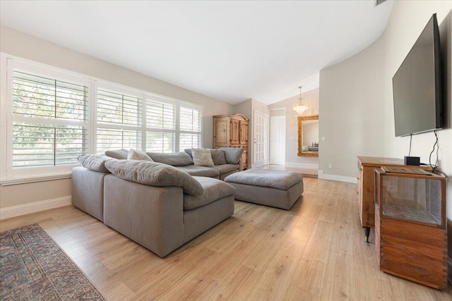 living room with lofted ceiling, plenty of natural light, and light hardwood / wood-style floors