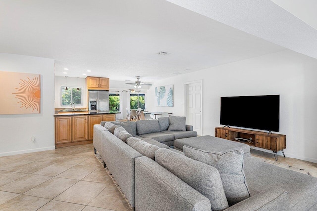 tiled living room featuring sink, a textured ceiling, and ceiling fan