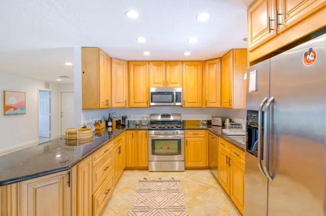 kitchen featuring kitchen peninsula, light tile patterned floors, dark stone counters, and stainless steel appliances