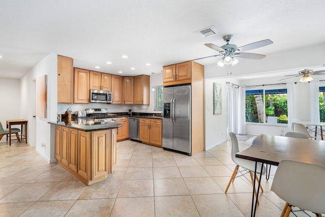 kitchen with light tile patterned flooring, ceiling fan, stainless steel appliances, kitchen peninsula, and a textured ceiling