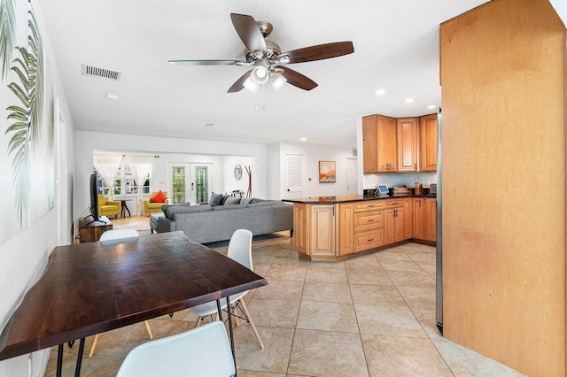 kitchen with ceiling fan, light tile patterned floors, french doors, and kitchen peninsula