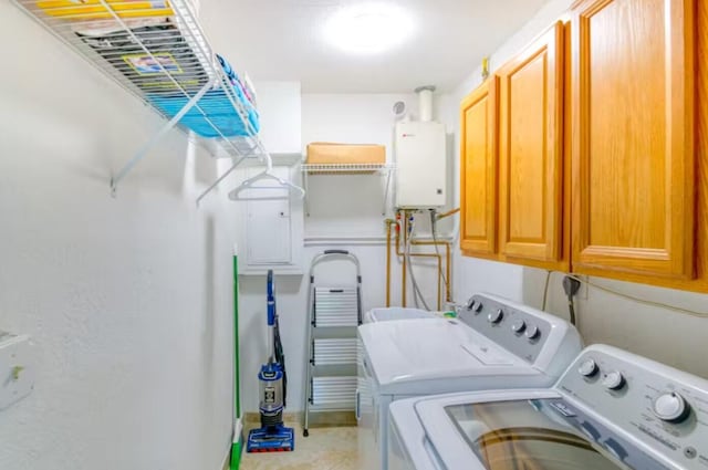 clothes washing area featuring cabinets, tankless water heater, and washer and dryer