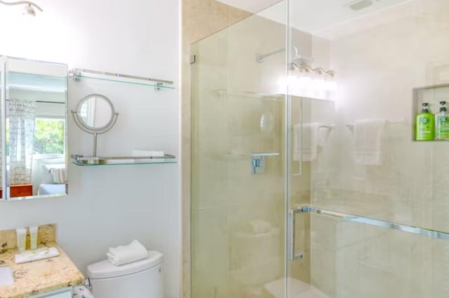 bathroom featuring walk in shower, vanity, and toilet