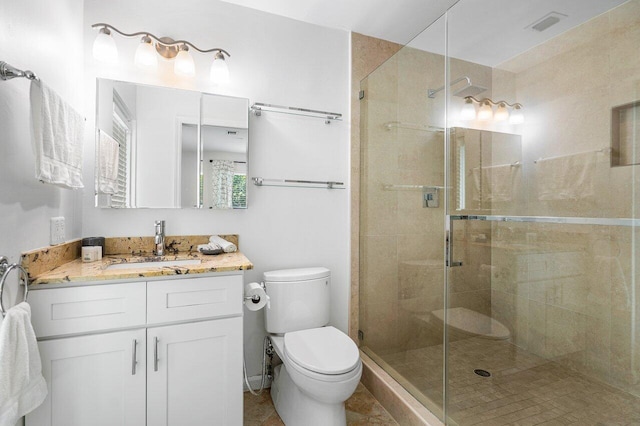 bathroom featuring vanity, walk in shower, and toilet