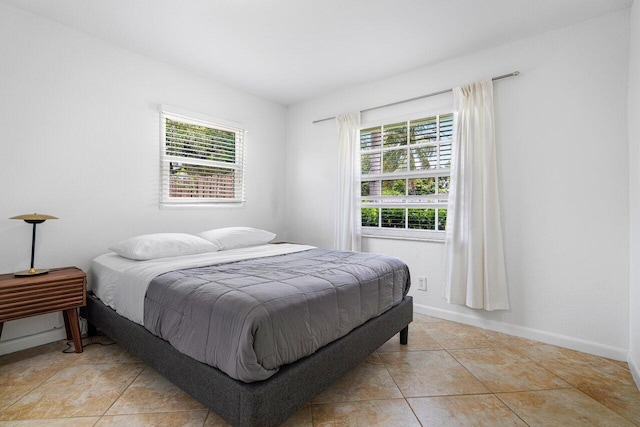 bedroom with light tile patterned flooring and multiple windows