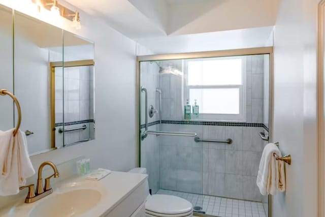 bathroom with walk in shower, vanity, and toilet