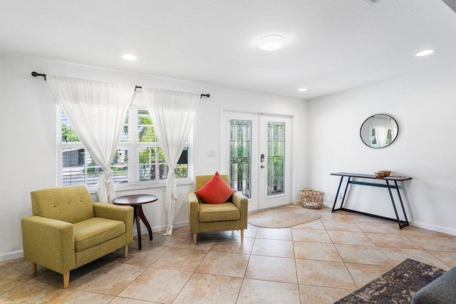 sitting room featuring light tile patterned flooring and french doors