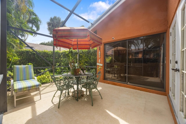 view of patio featuring glass enclosure