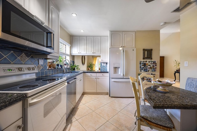 kitchen with ceiling fan, light tile patterned floors, sink, appliances with stainless steel finishes, and decorative backsplash