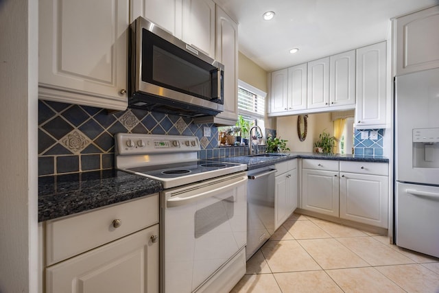 kitchen with light tile patterned floors, white cabinets, stainless steel appliances, and sink