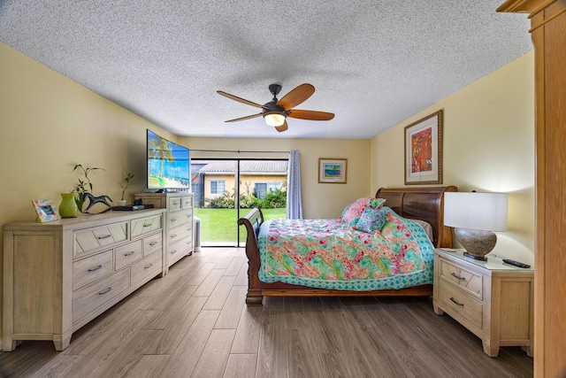 bedroom with a textured ceiling, access to outside, ceiling fan, and light hardwood / wood-style flooring