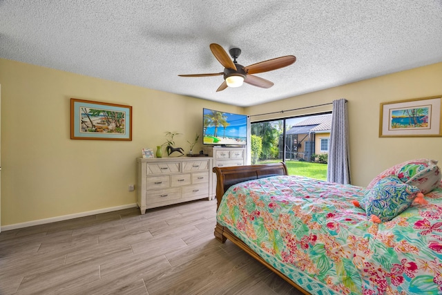 bedroom with light hardwood / wood-style flooring, ceiling fan, and a textured ceiling