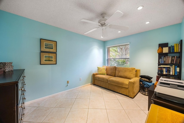 living room featuring a textured ceiling, light tile patterned floors, and ceiling fan